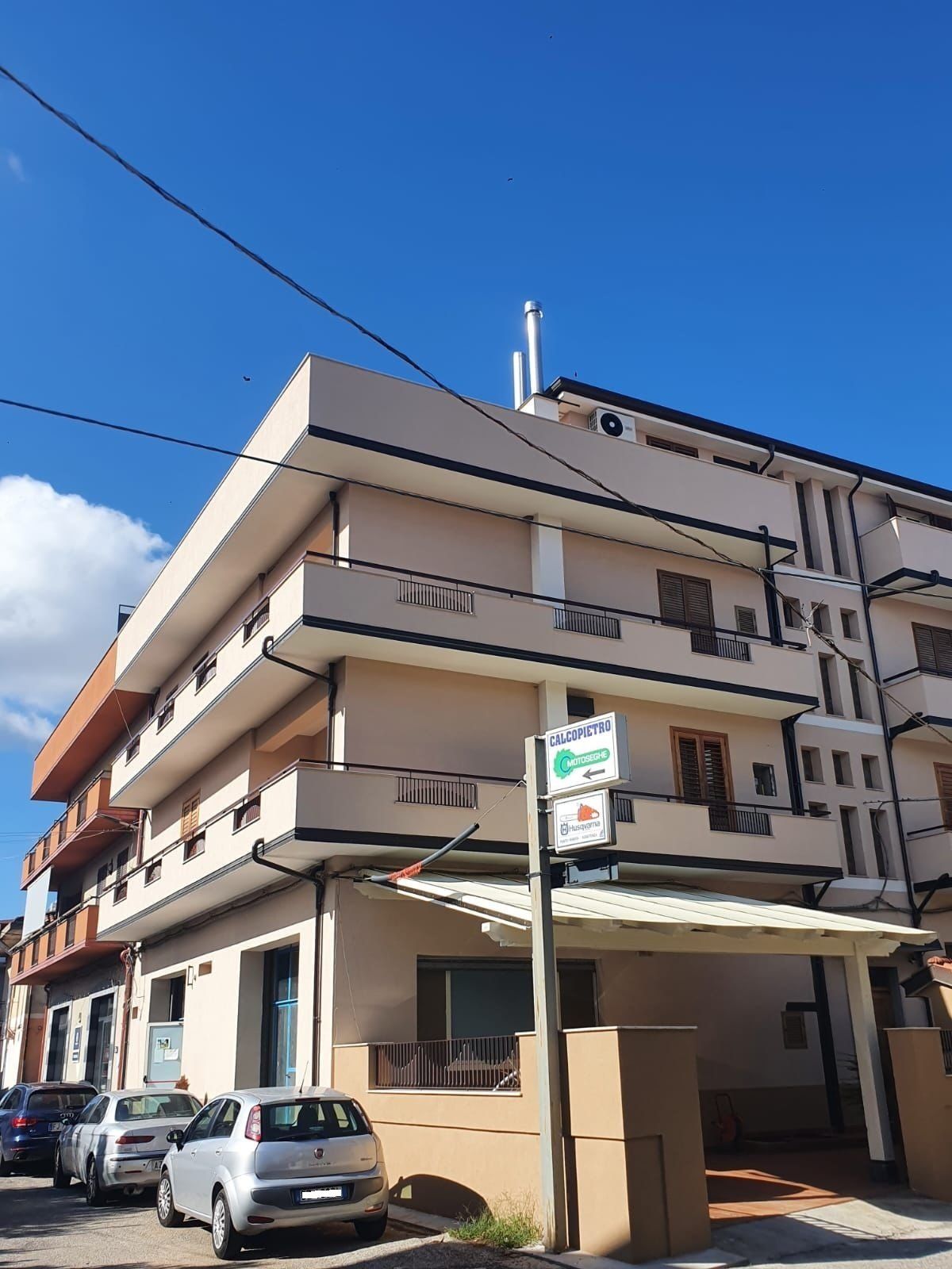 Un grande edificio con auto parcheggiate di fronte