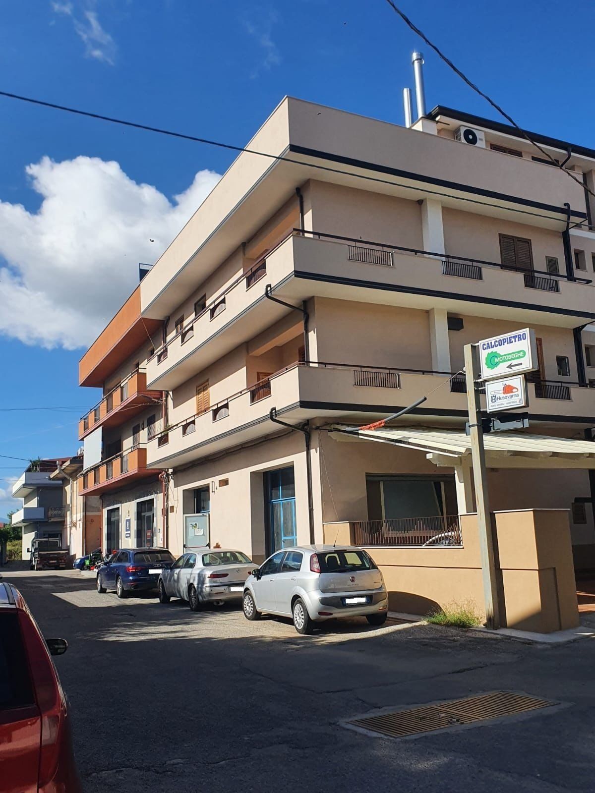 Un grande edificio con auto parcheggiate di fronte