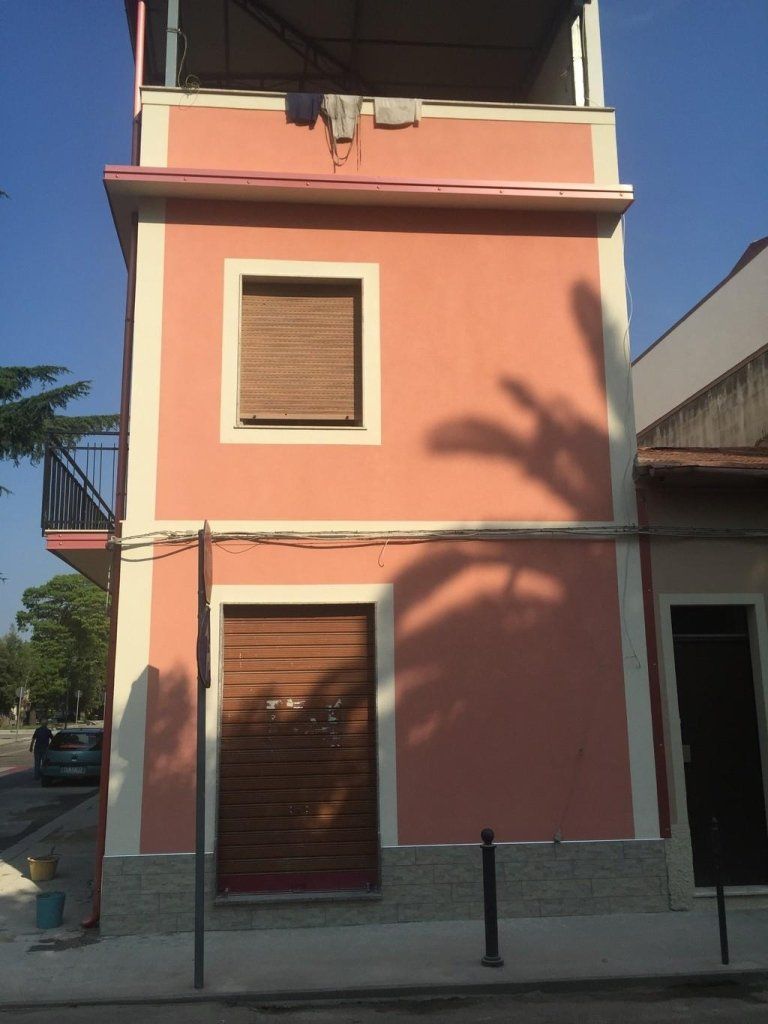 Un edificio rosa con un balcone in cima