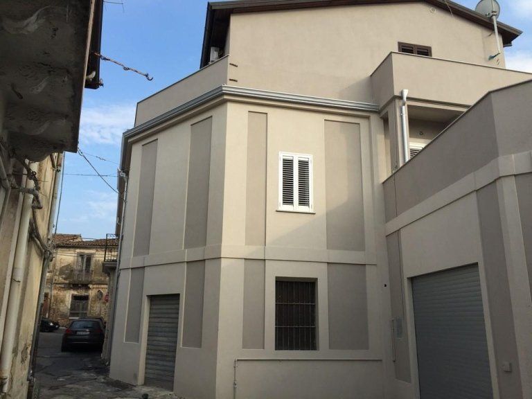 Un angolo di un edificio con una finestra e delle persiane