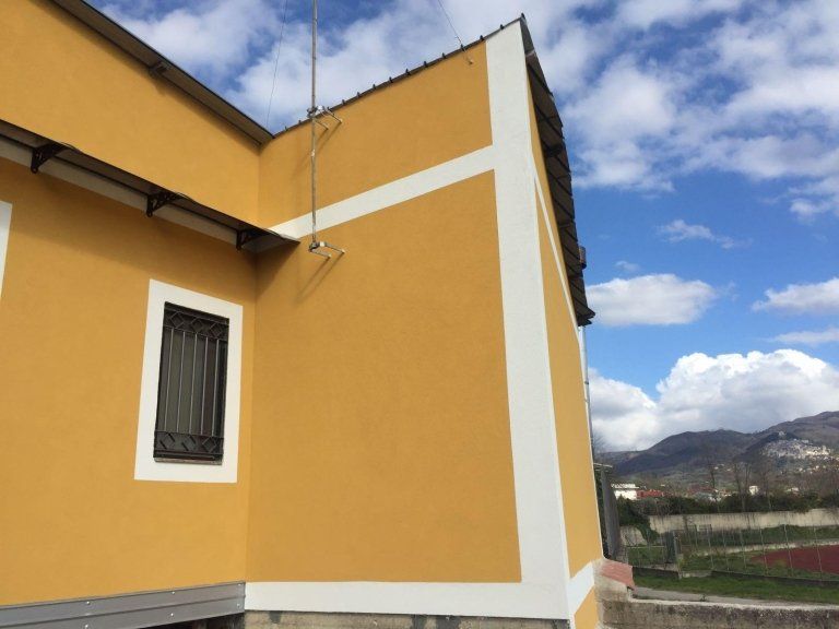 Un edificio giallo con una striscia bianca sul lato