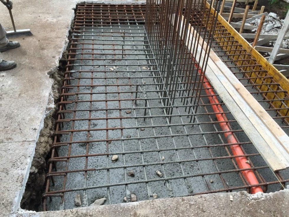 Un buco nel terreno con una griglia metallica al suo interno