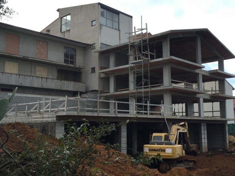 Un escavatore Komatsu è parcheggiato davanti a un edificio in costruzione