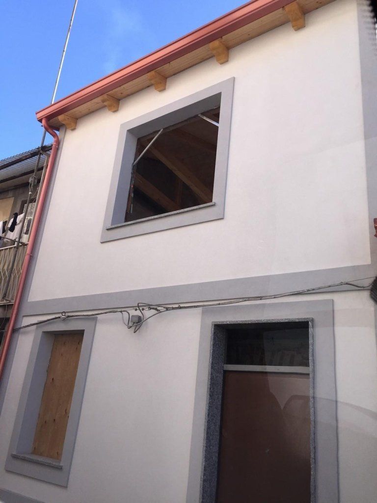 Un edificio bianco con una finestra chiusa con assi