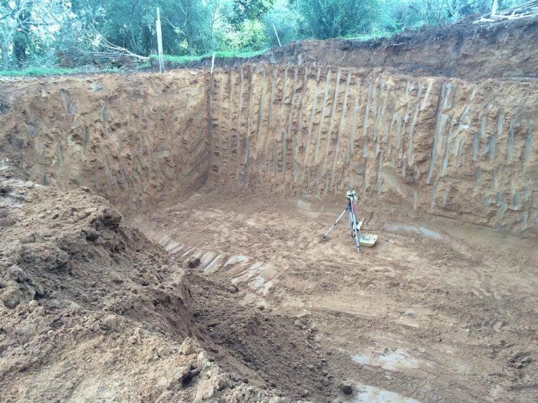 Un grande mucchio di terra si trova in mezzo a un campo sterrato.