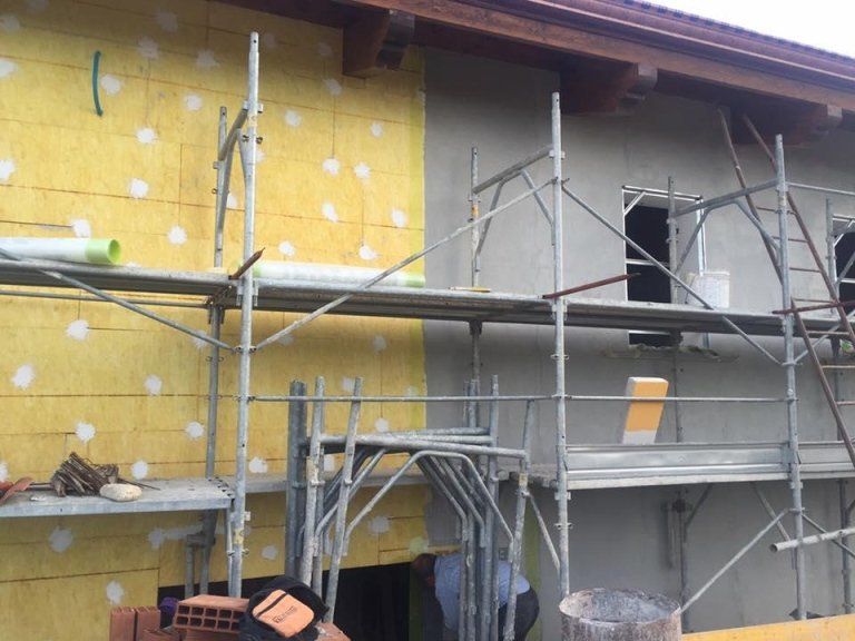 Un edificio in costruzione con impalcature sul lato