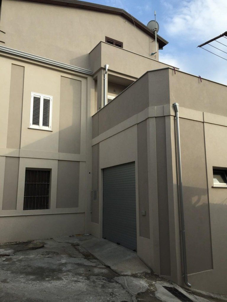 Un edificio con un garage e una finestra sul lato