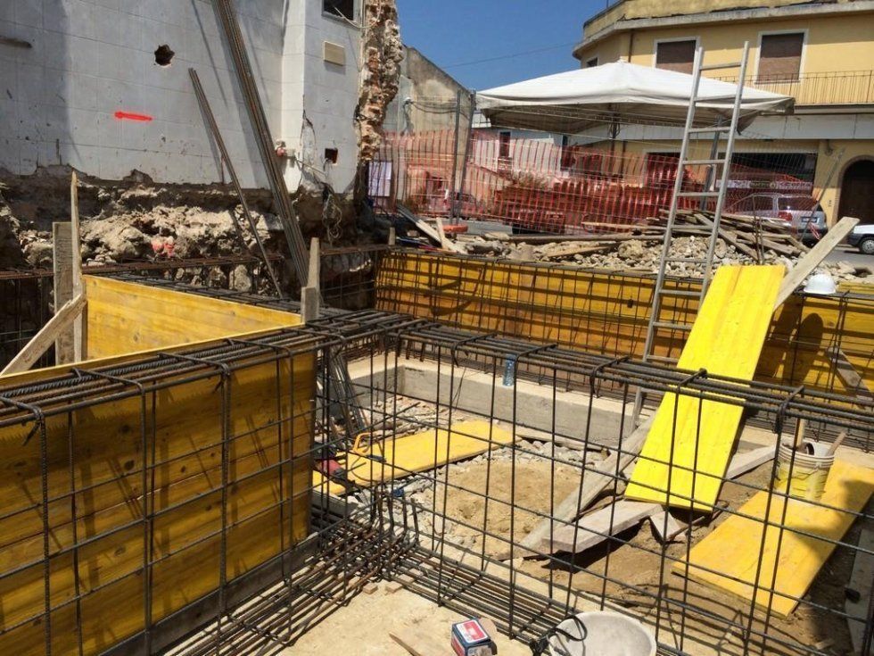 Un cantiere con un cartello giallo appoggiato a terra