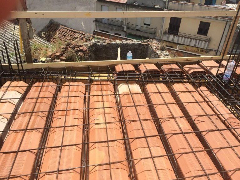 Un edificio in costruzione con mattoni e barre di metallo