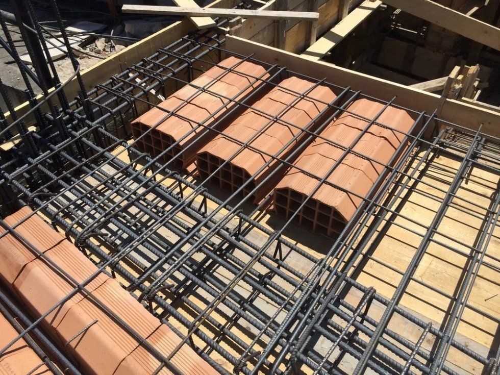 Un cantiere con molte barre d'acciaio e mattoni