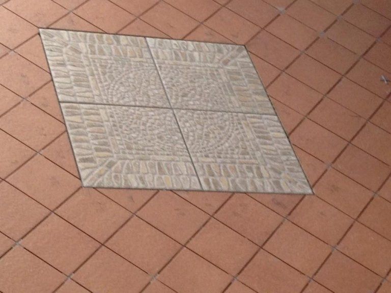 Una piastrella quadrata al centro di un pavimento a scacchi