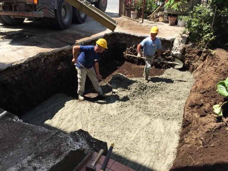 Due uomini che indossano caschi protettivi stanno lavorando in un cantiere edile