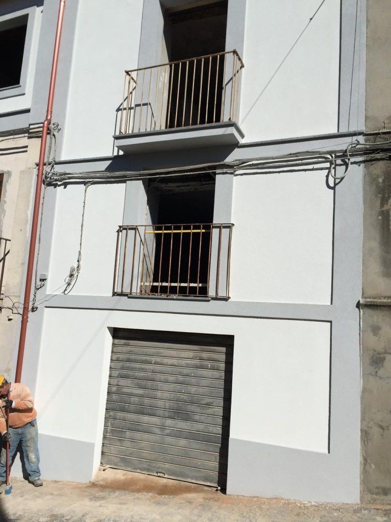 Un uomo è in piedi davanti a un edificio con un balcone