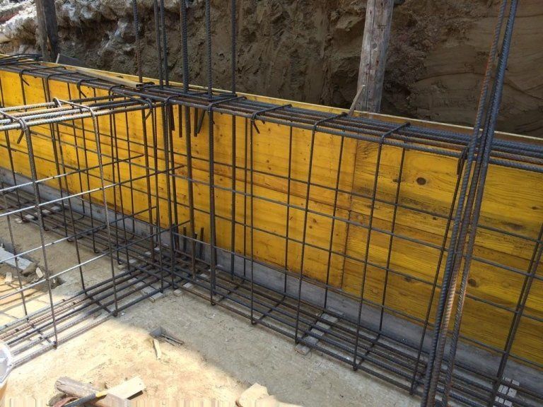 Si sta costruendo una recinzione metallica accanto a un muro di legno.