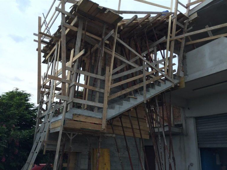 Un edificio in costruzione con impalcature e scale in legno