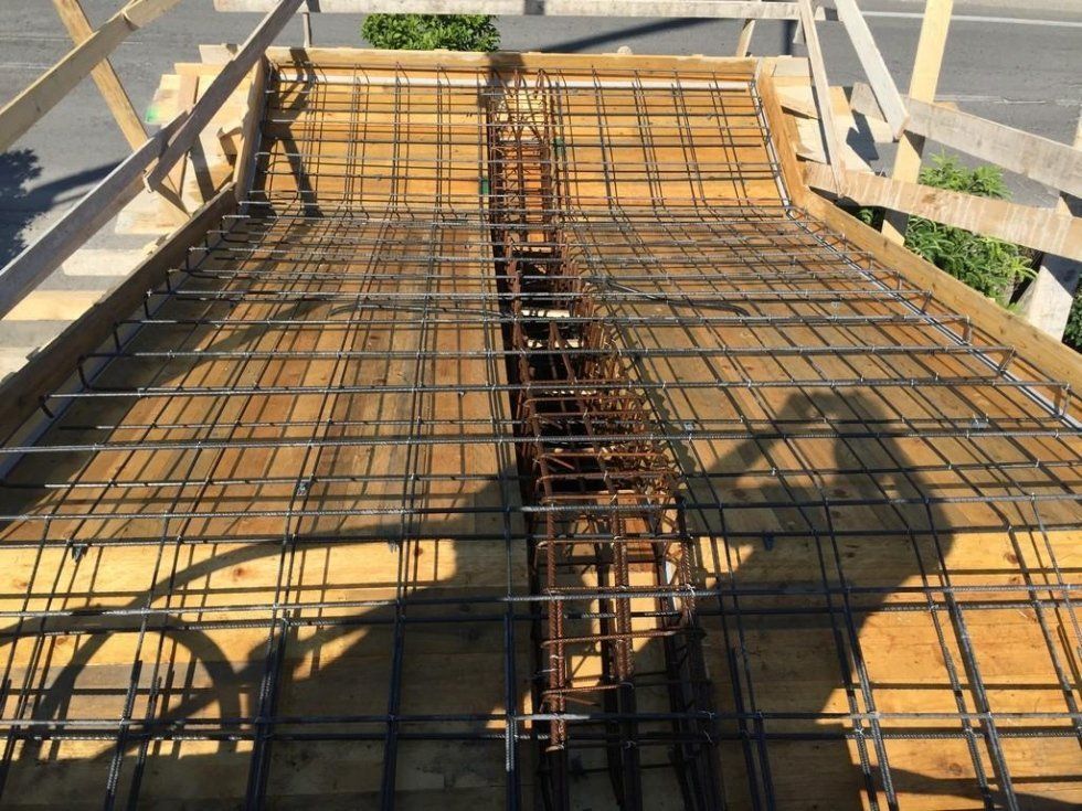 L'ombra di una persona viene proiettata su una griglia metallica su una superficie di legno.