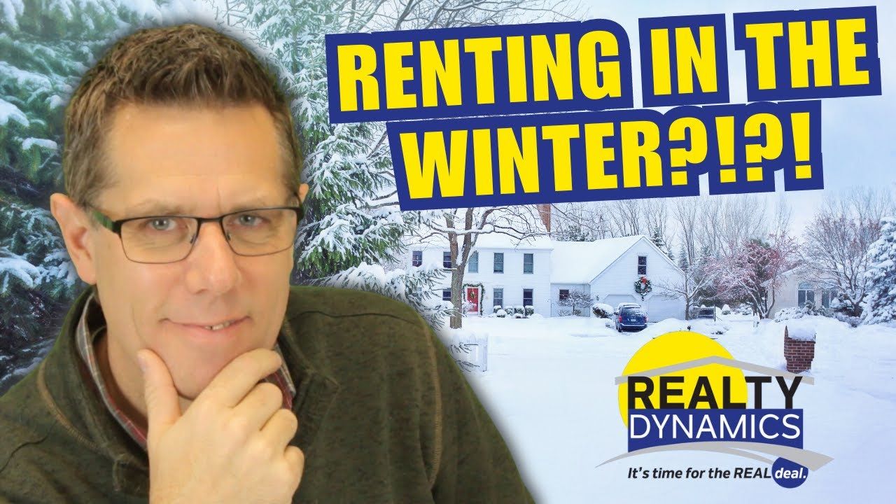 a man wearing glasses is standing in front of a snowy house . renting in the winter time, benefits