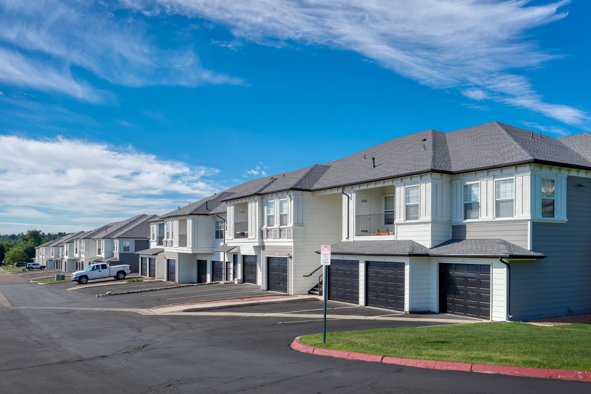 Exterior view of row townhome-style apartment buildings with attached garages.