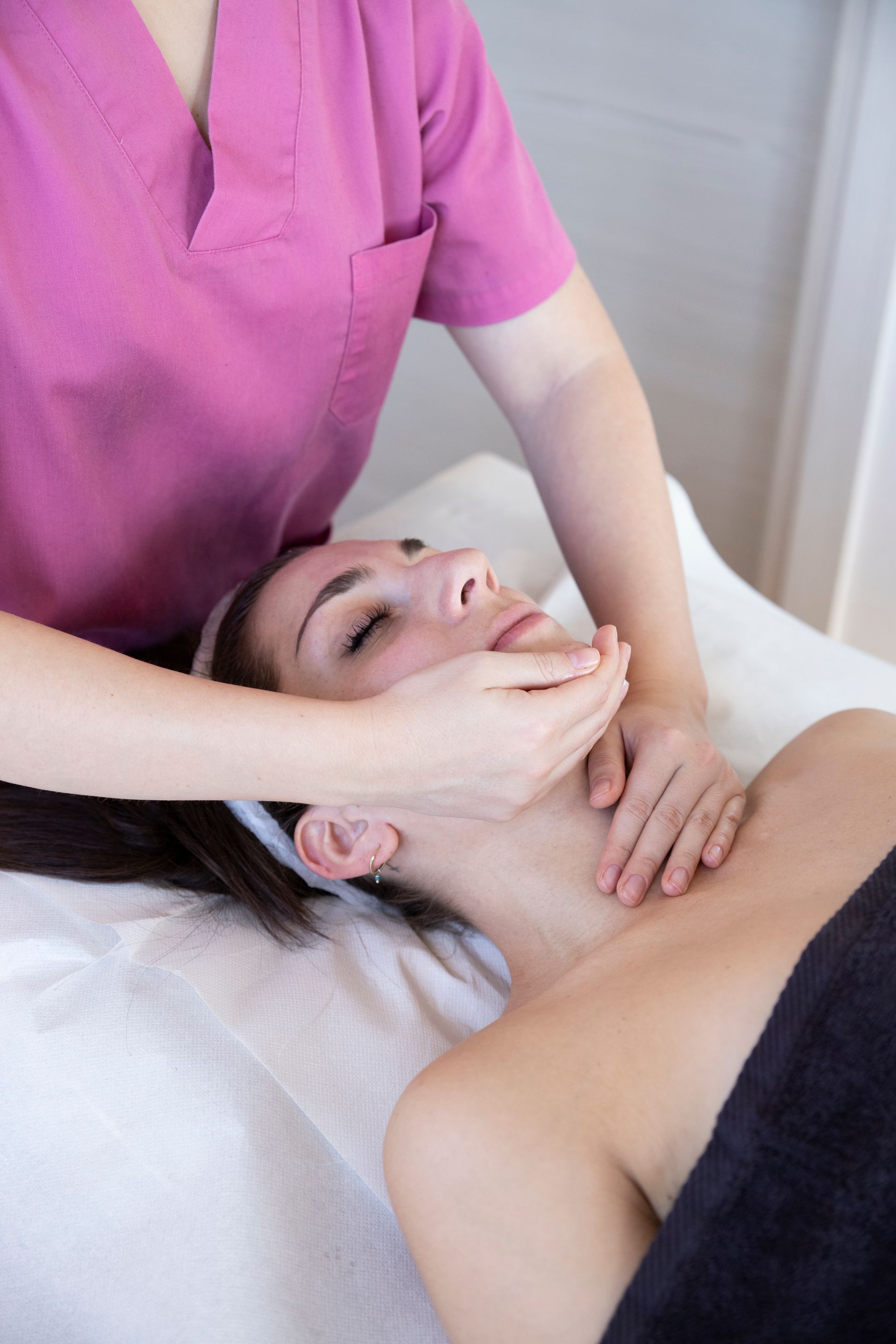 Massaggiatrice che applica un massaggio viso