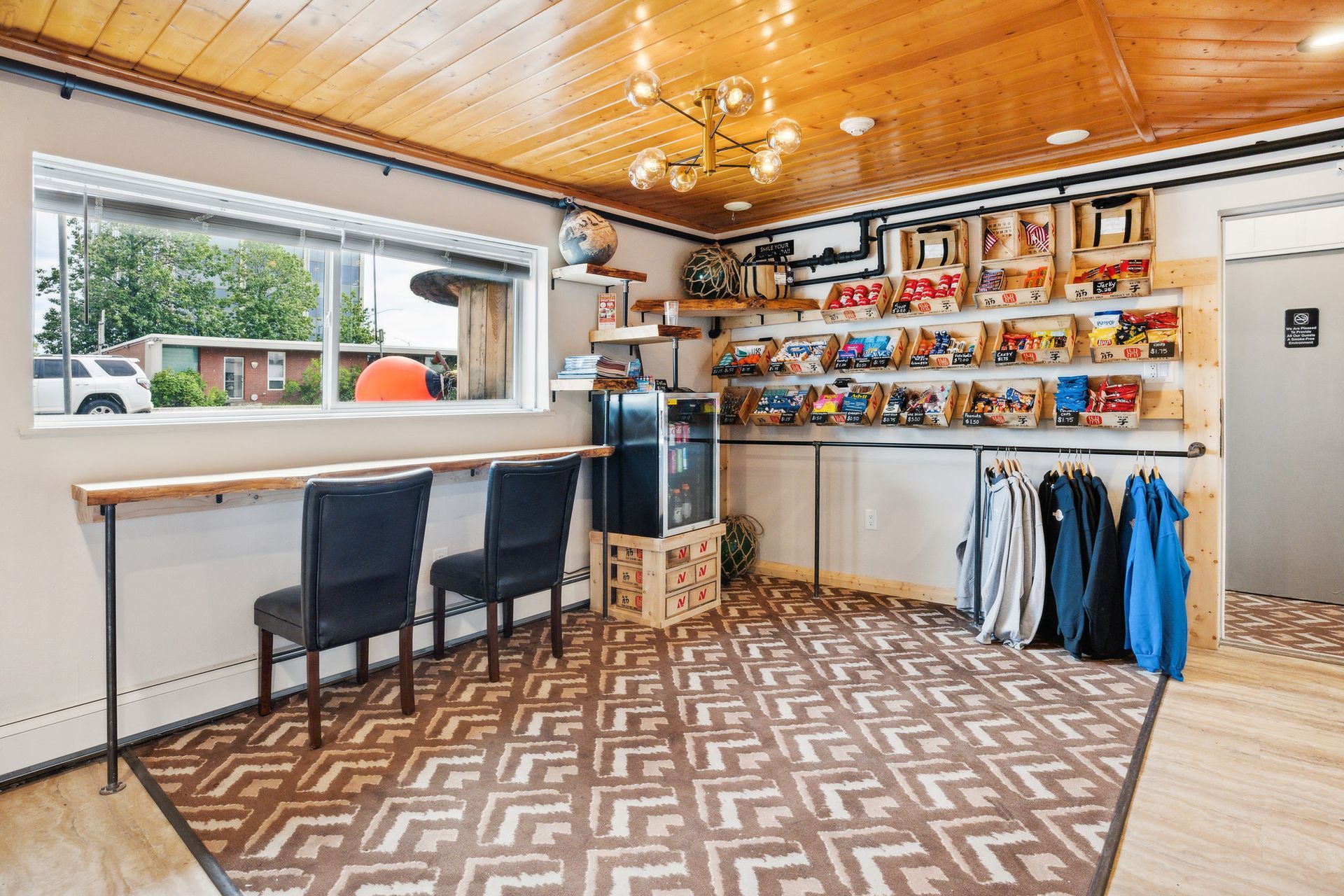 A room with a rug , chairs , a table and a window.