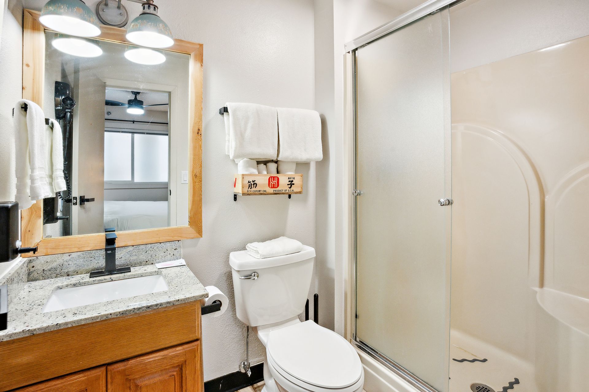 A bathroom with a toilet , sink and shower.