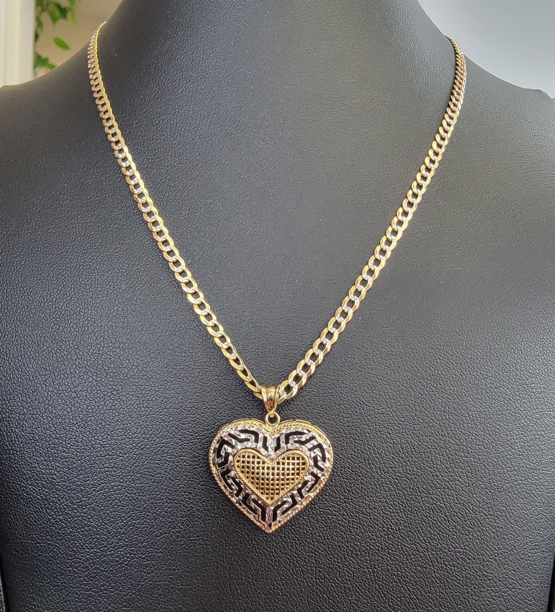 A necklace and bracelet are on a black mannequin