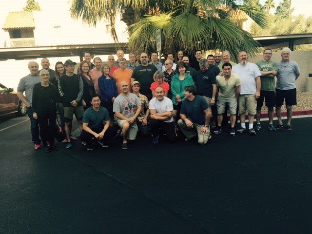 A group of people posing for a picture in a parking lot