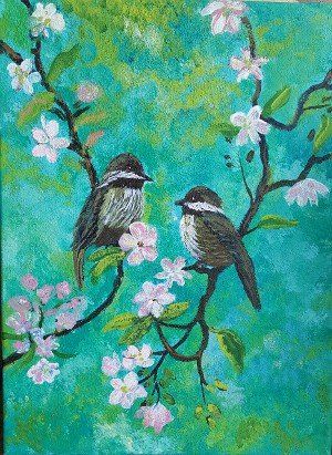 Two small birds sitting on a branch with flower blossoms
