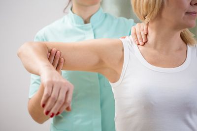 Back Pain Therapy — Physical Therapist Diagnosing Patient in Lafayette, LA