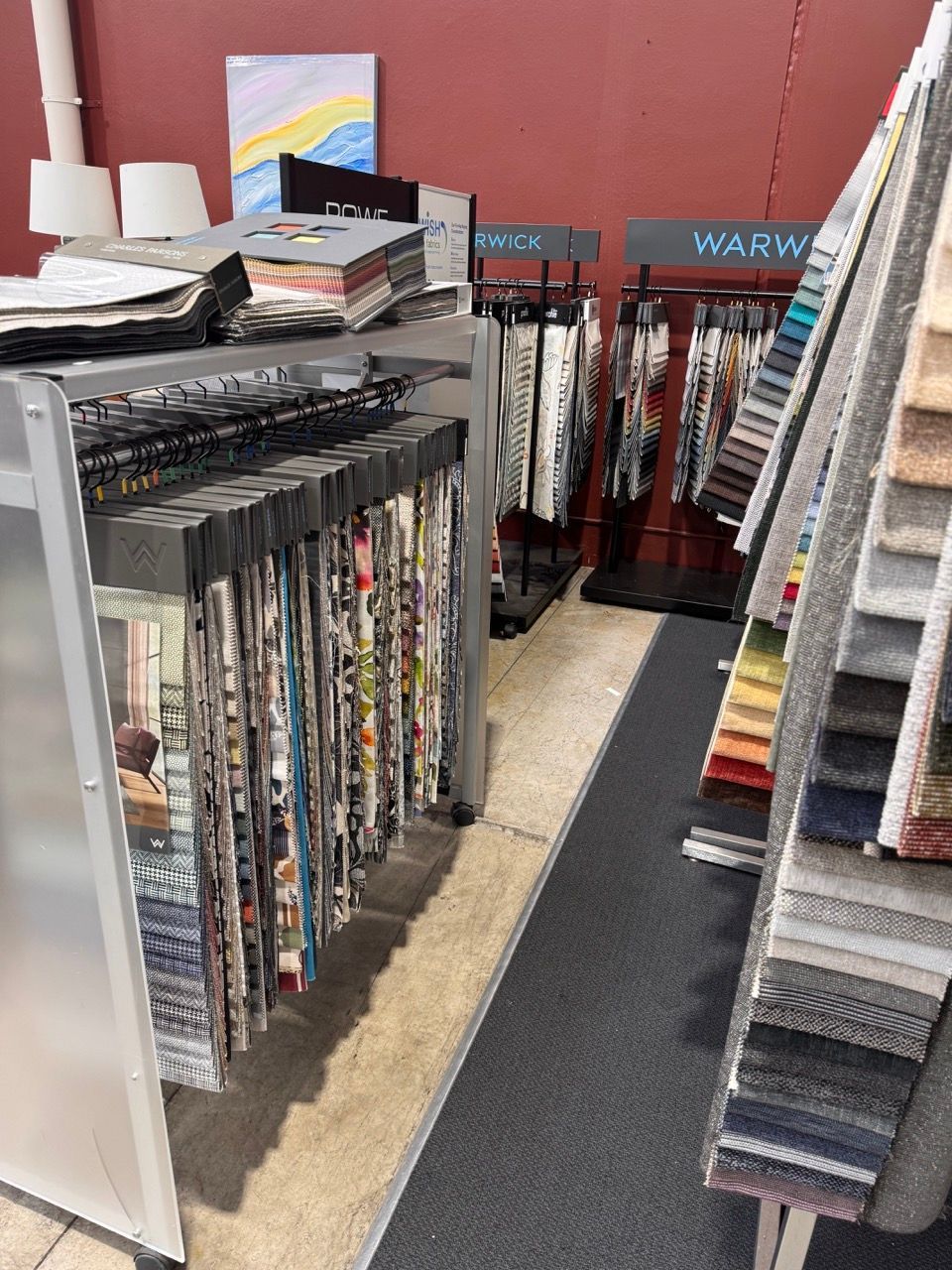 Fabric swatches displayed on racks in a store, showcasing various colors and patterns.