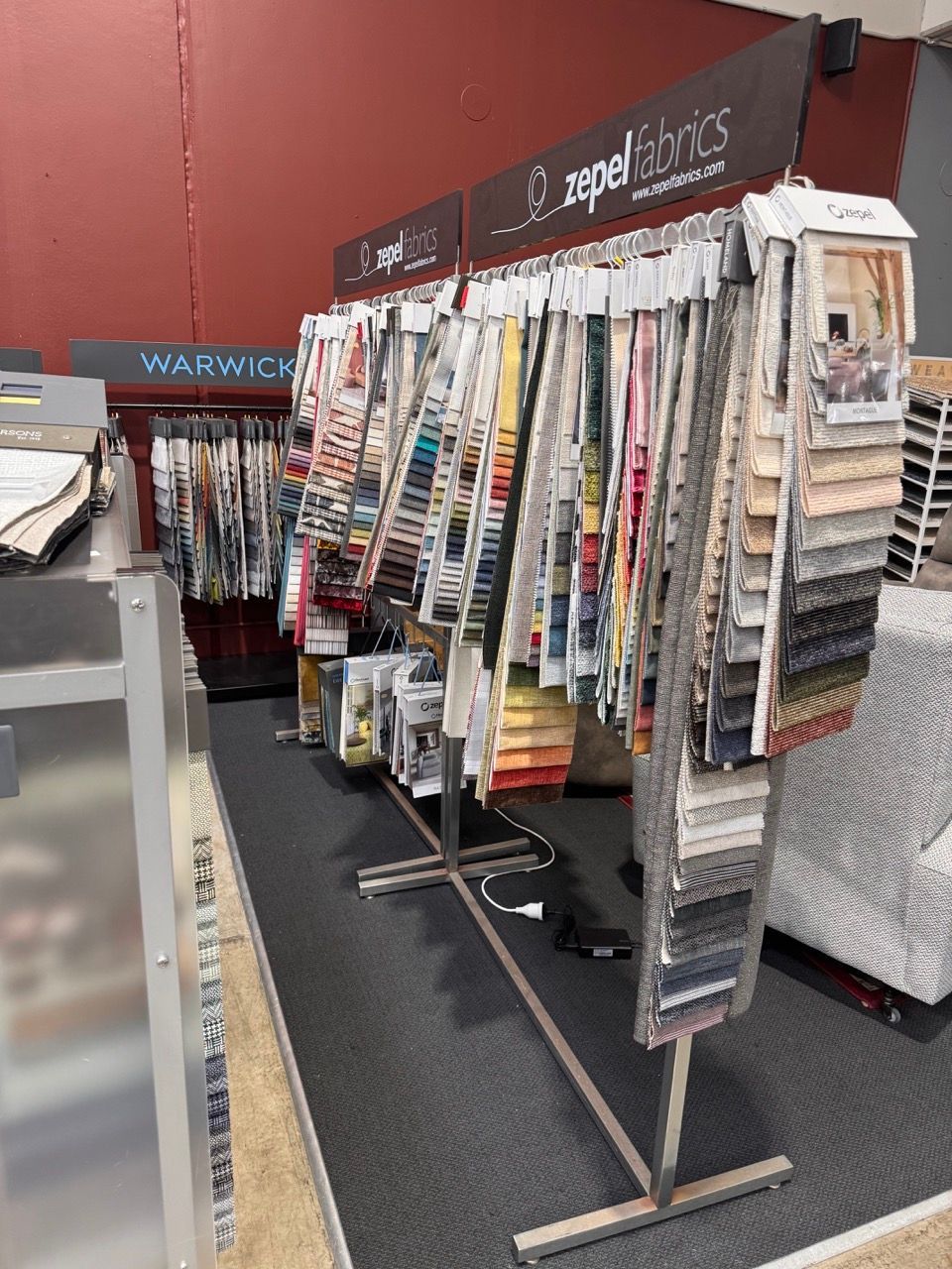 Fabric samples on display racks in a store. Includes fabric brands 