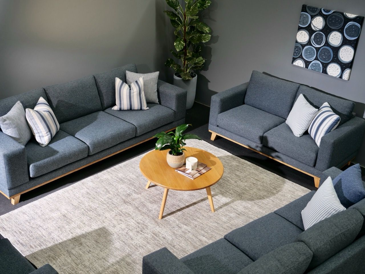 Living room with gray sofas, wooden coffee table, rug, and wall art.