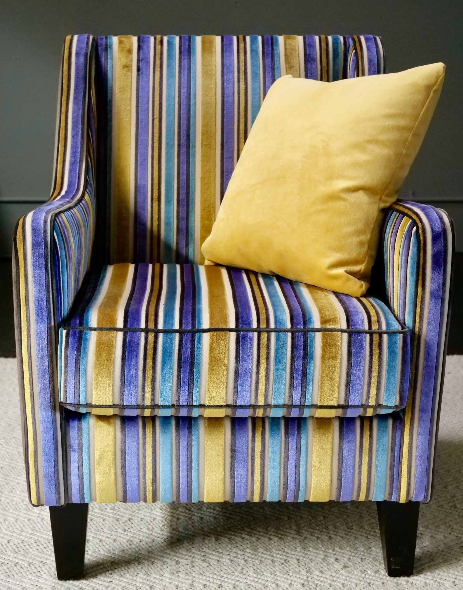 Armchair with blue, gold, and purple stripes, yellow pillow.