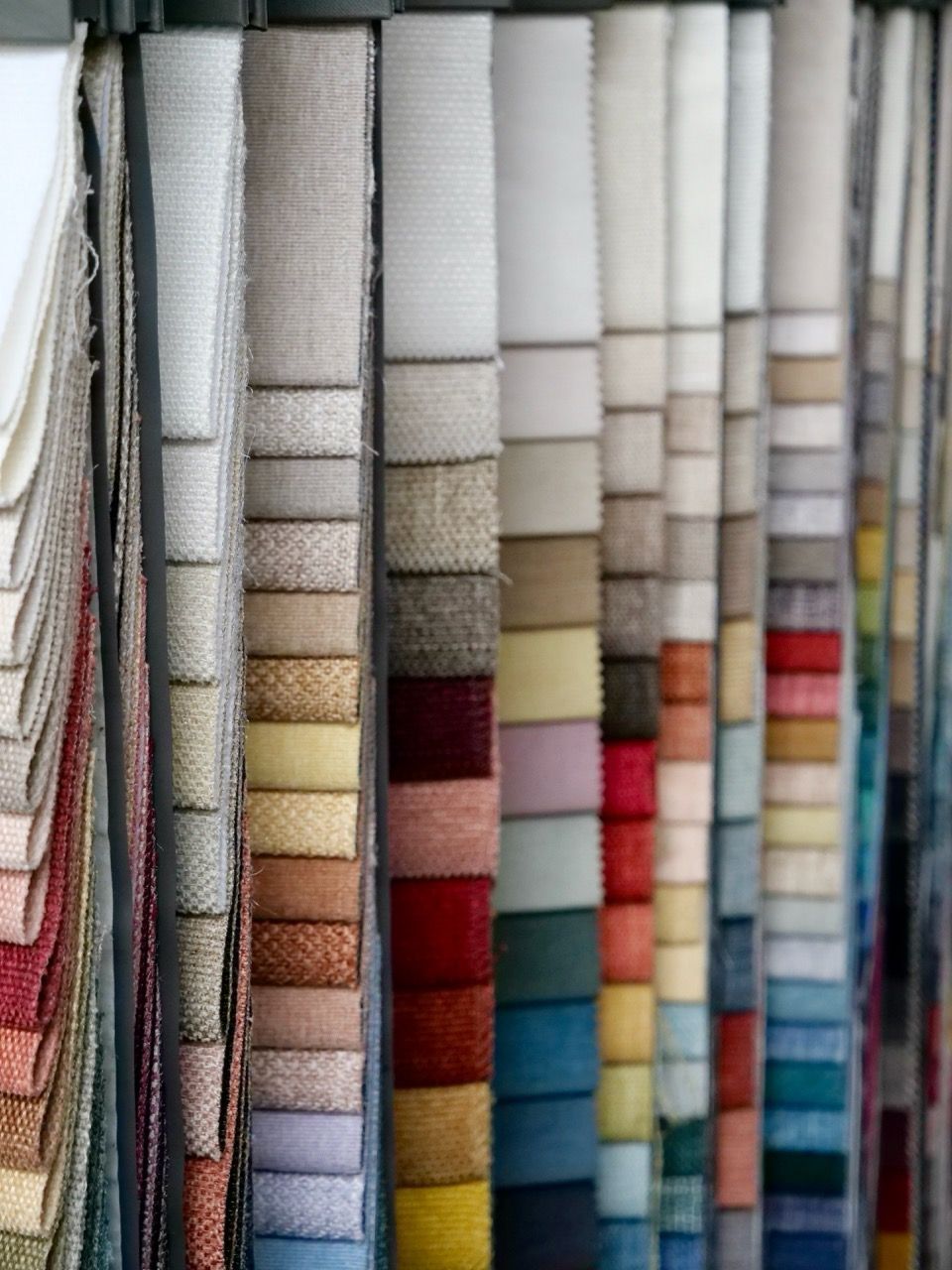 Fabric swatches of various colors hanging in a display, showcasing textile options.