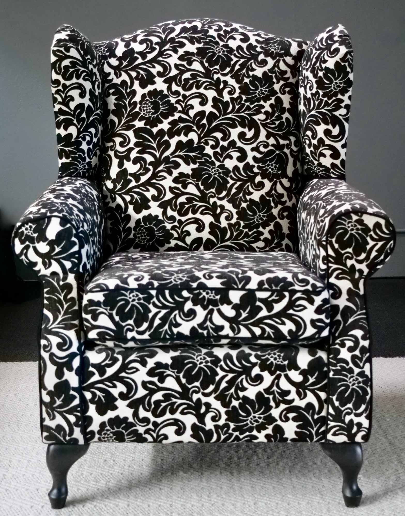 Wingback chair upholstered in black and white floral pattern.