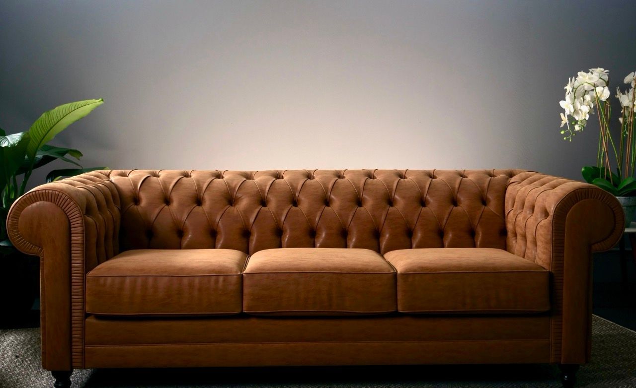 Brown tufted leather sofa in a modern room with plants and a neutral wall.