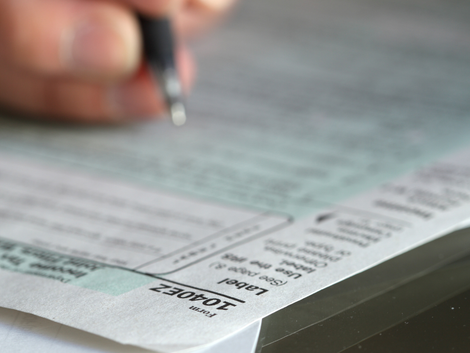 A person is writing on a piece of paper that says iowa