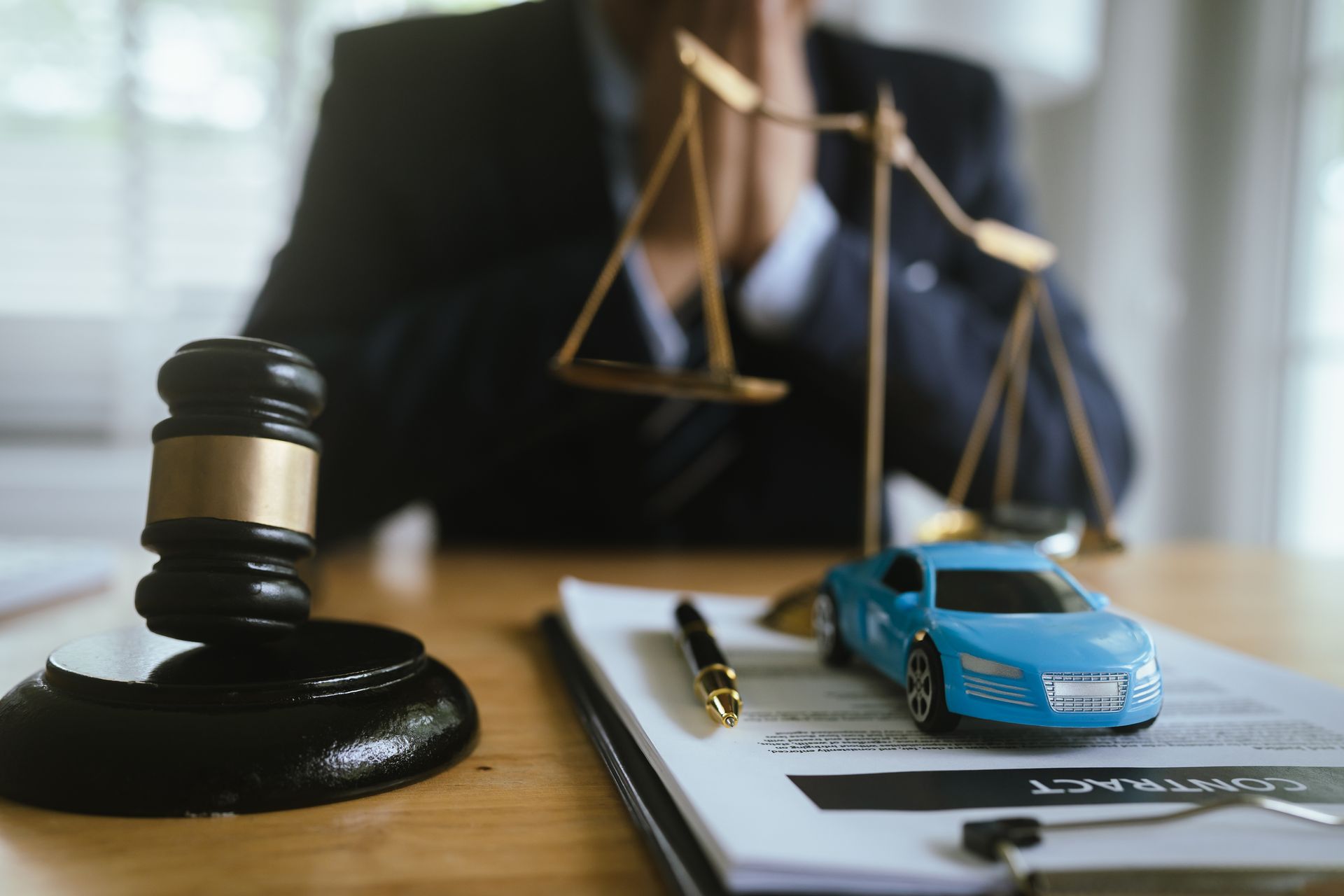 A lawyer in a suit signs legal documents with pen.