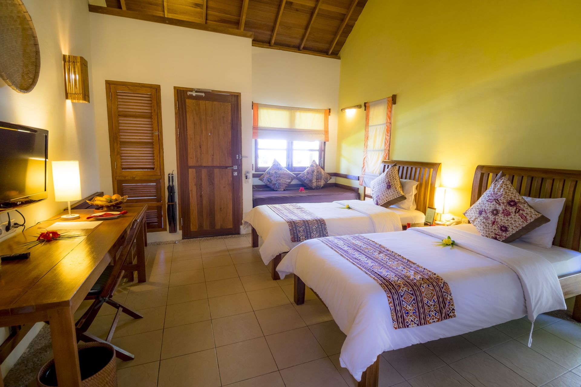 A hotel room with two beds , a desk and a television.