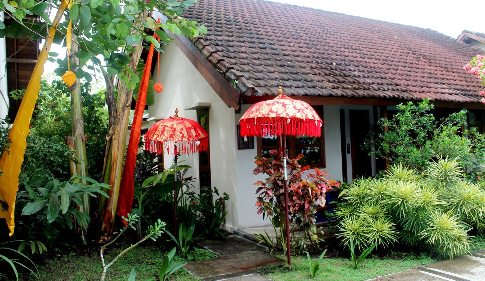 A white house with red umbrellas in front of it