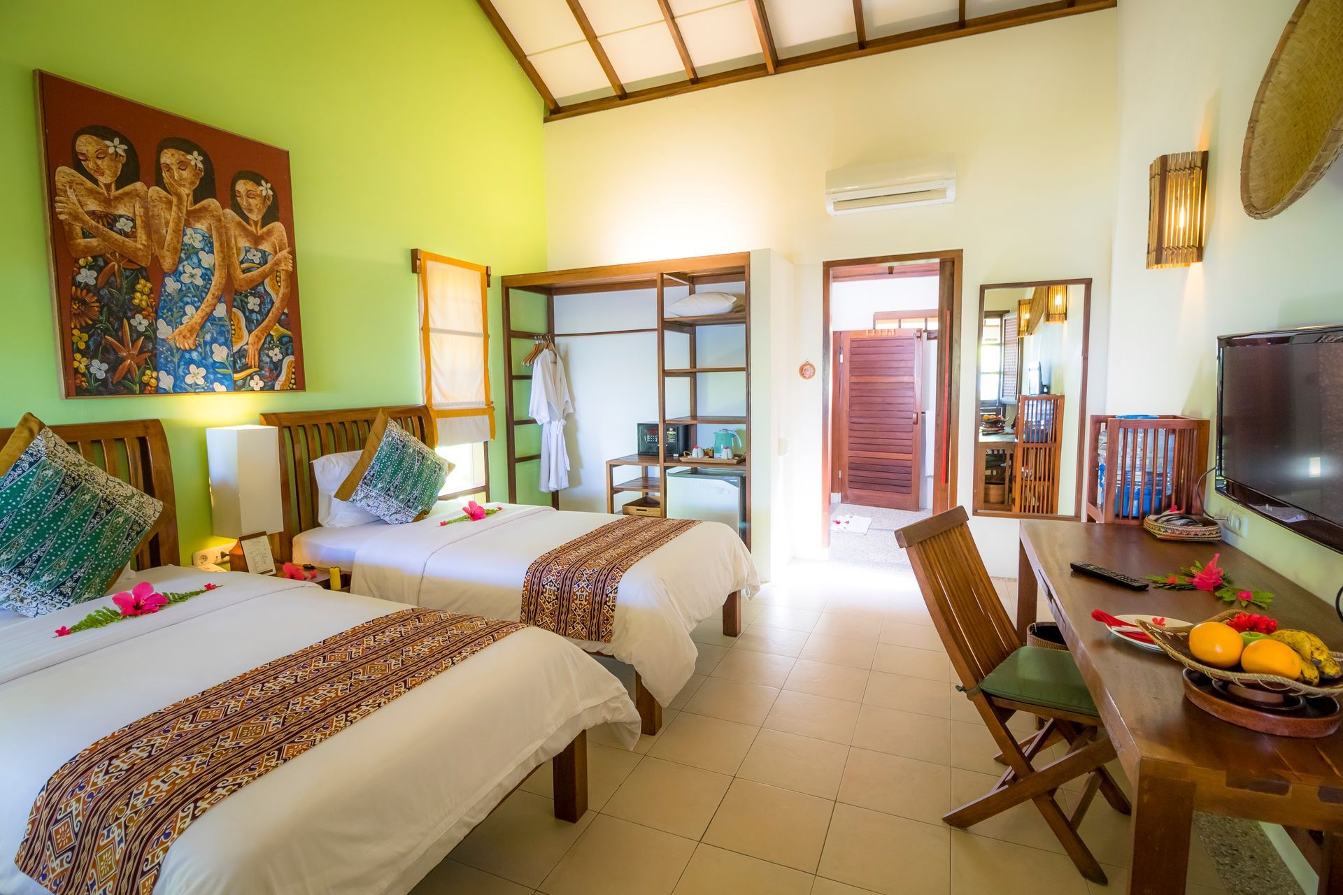 A hotel room with two beds , a desk and a television.
