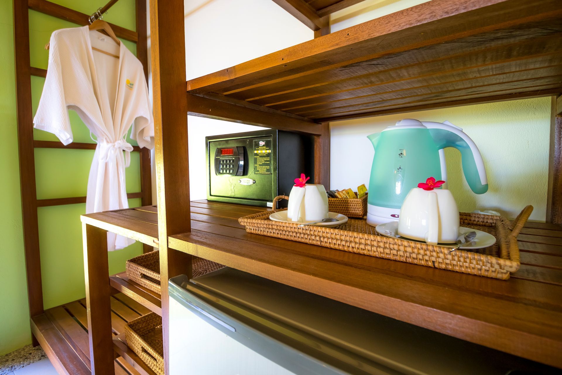 A wooden shelf with a kettle and cups on it.