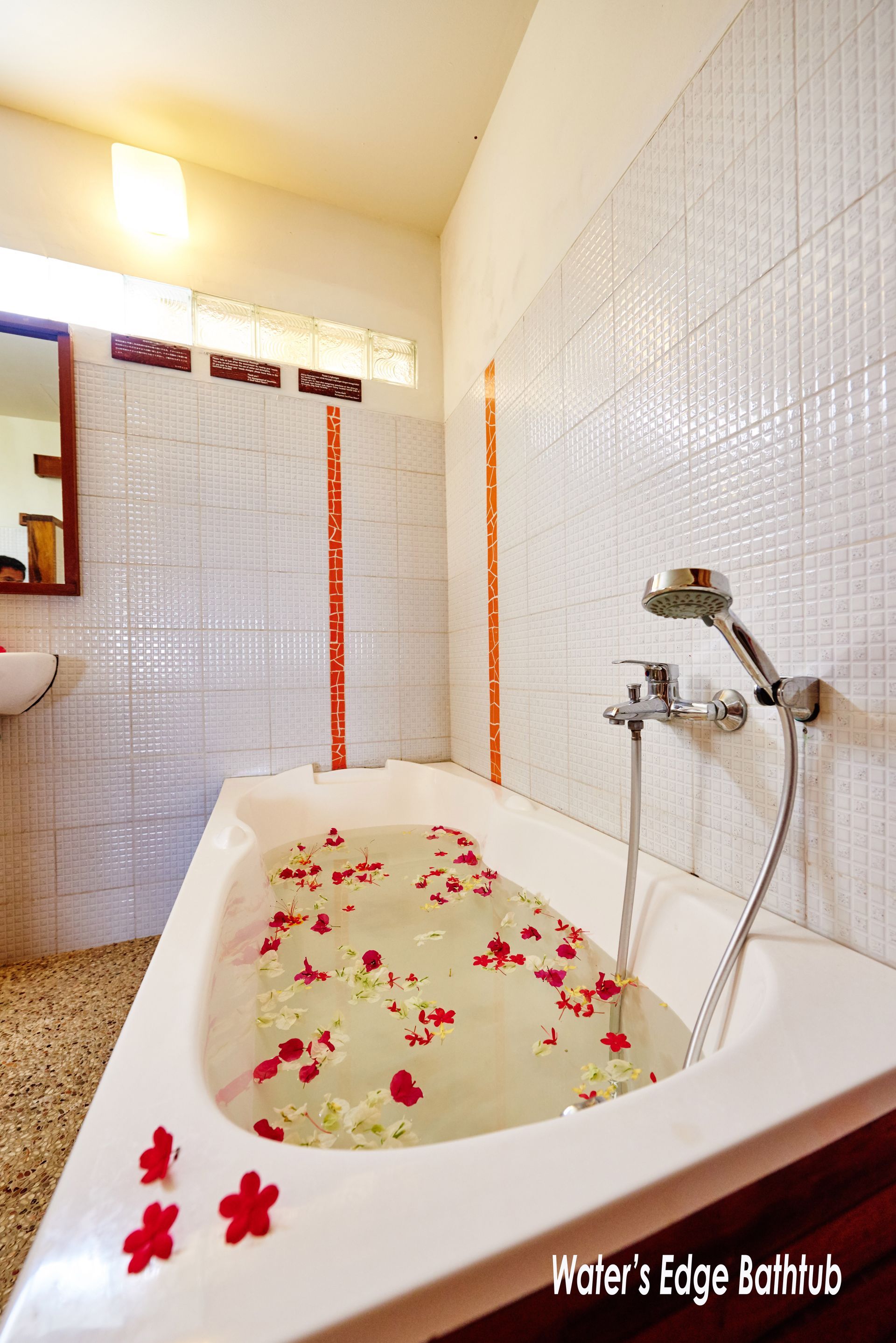 A bathtub filled with water and flowers in a bathroom