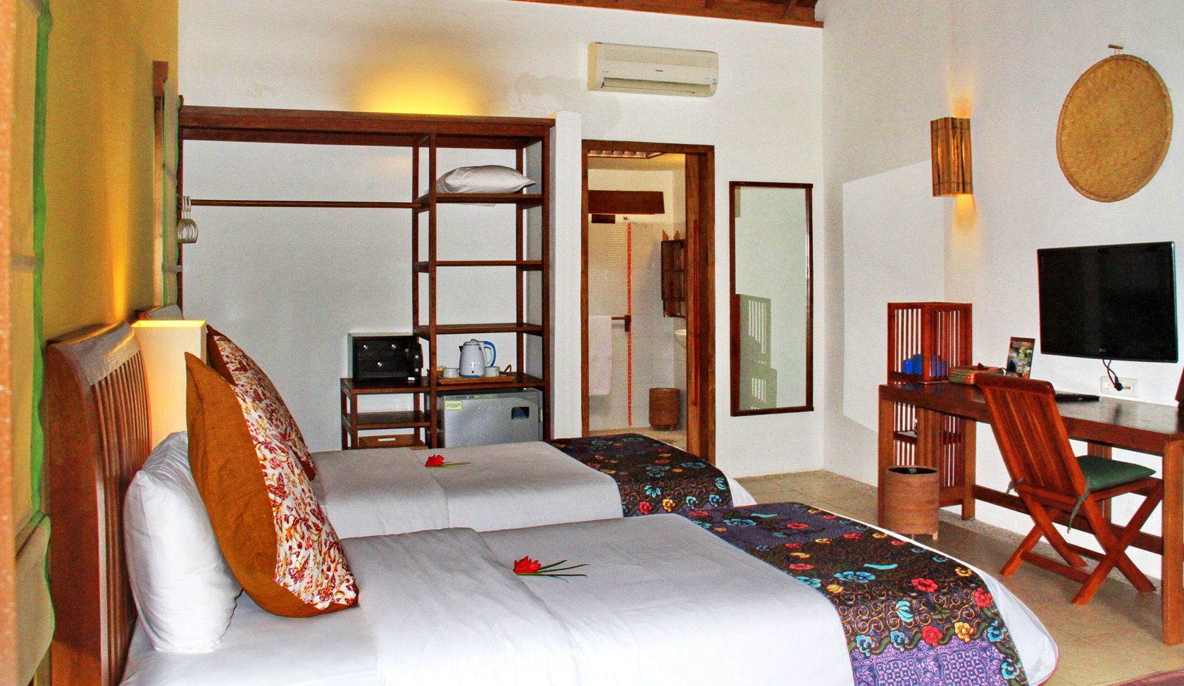 A hotel room with two beds , a desk and a television.