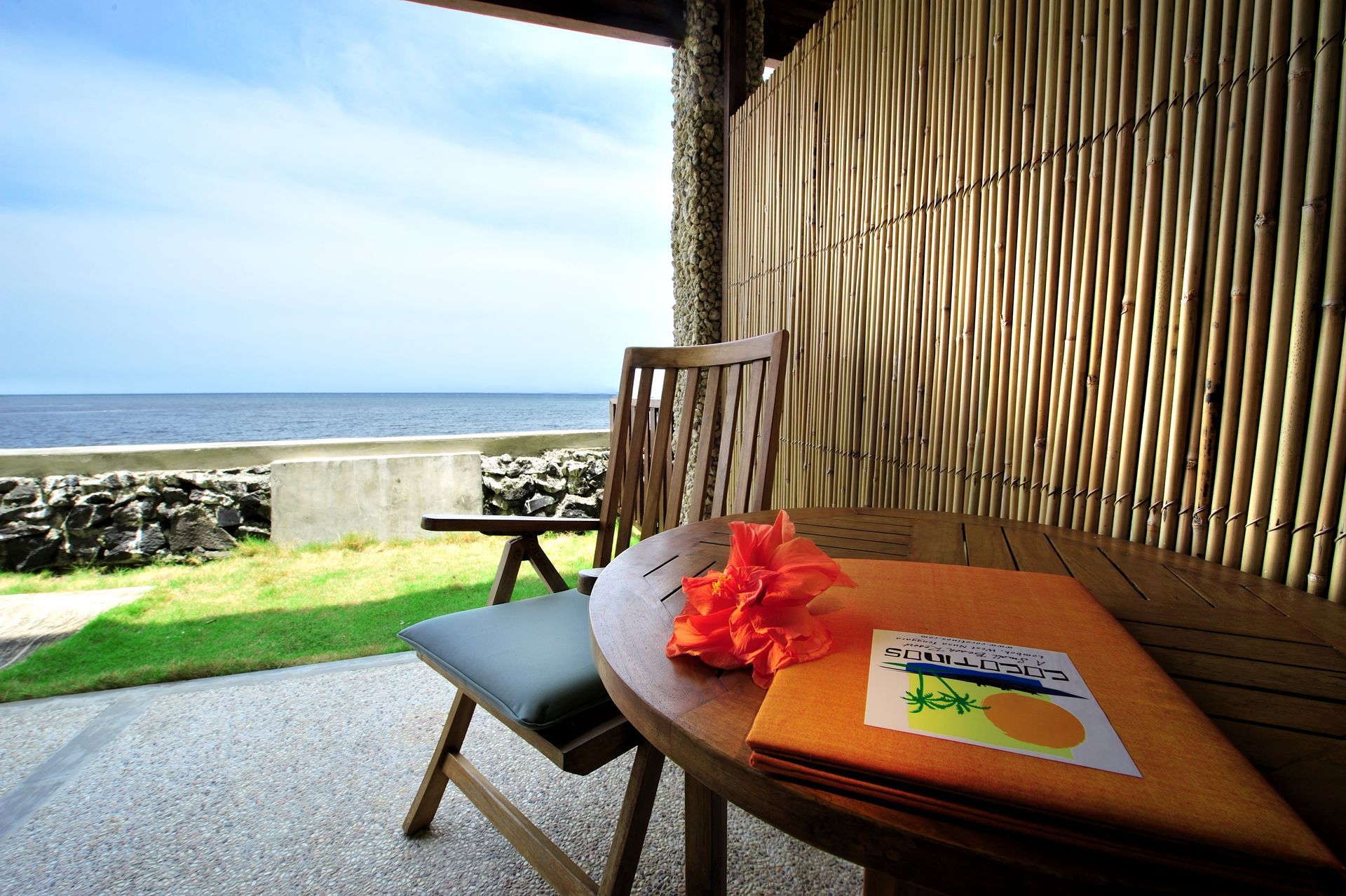 A table and chair on a balcony overlooking the ocean