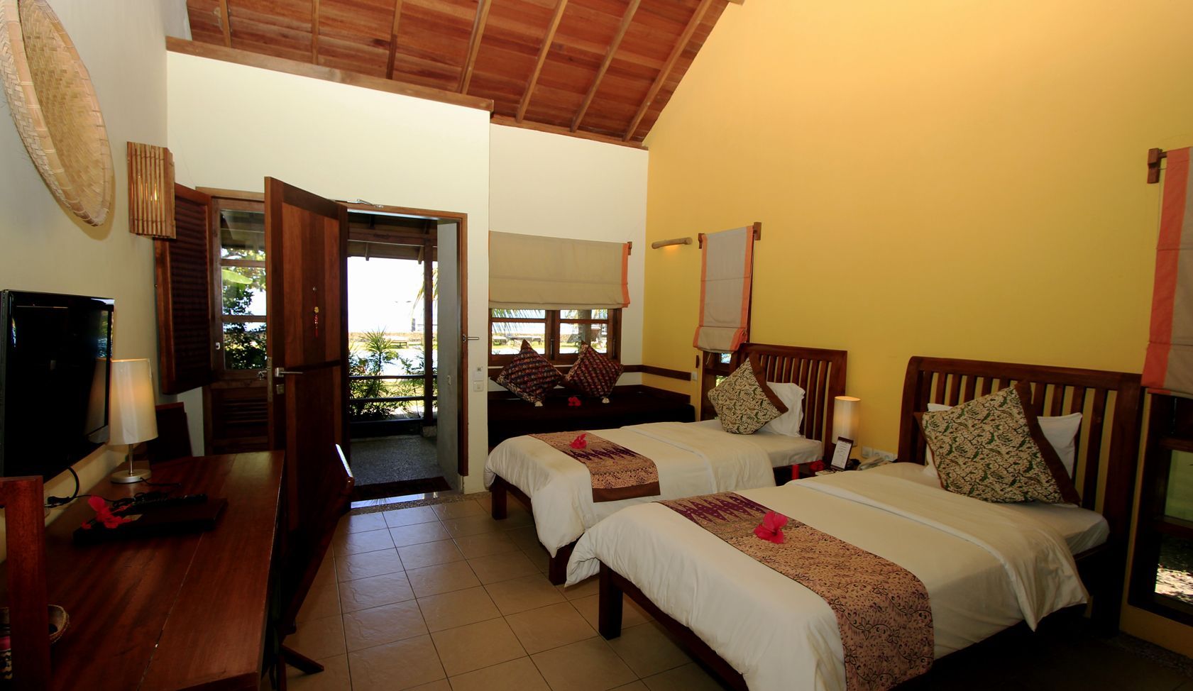 A hotel room with two beds and a television