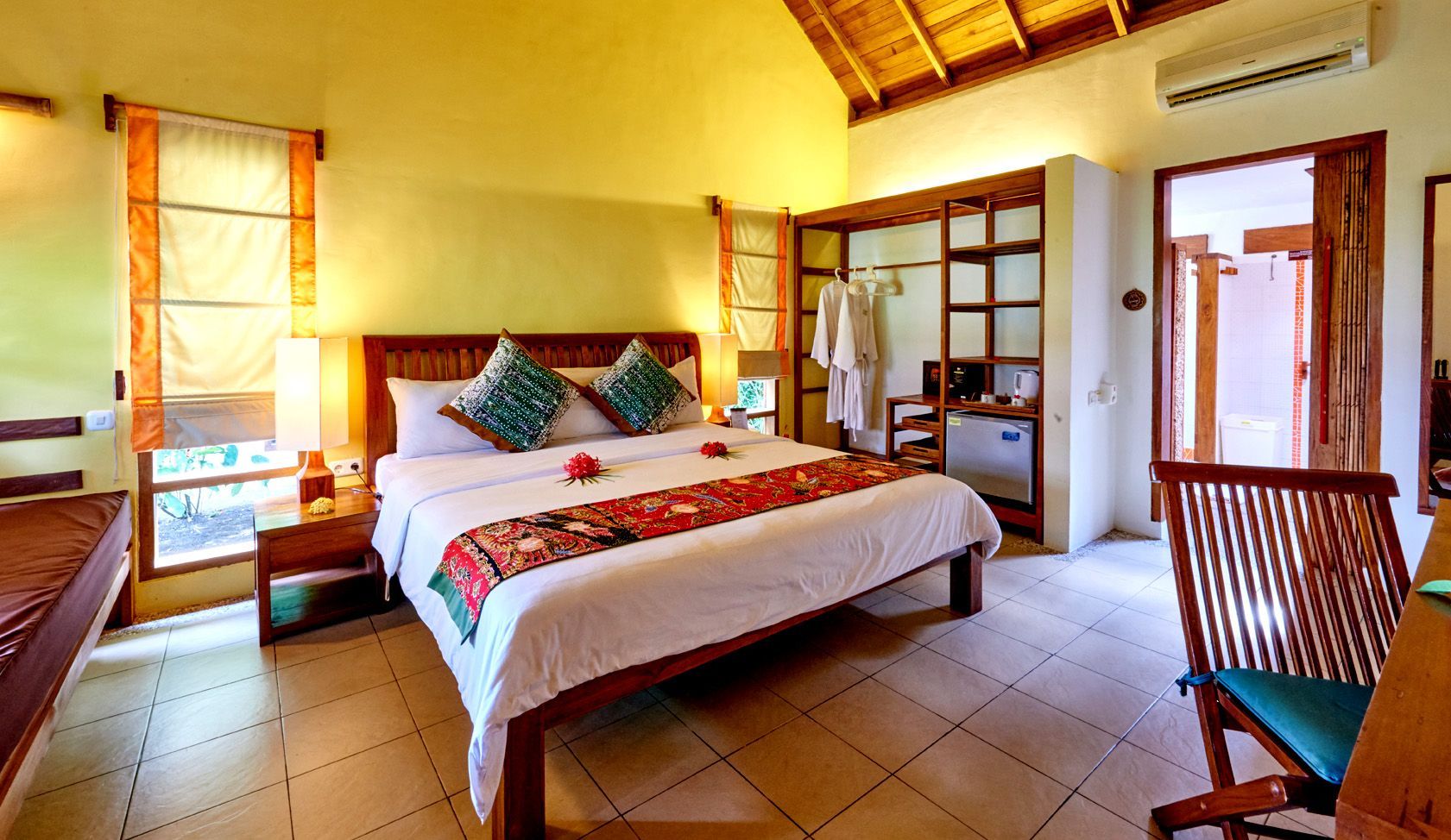 A hotel room with a large bed and a chair