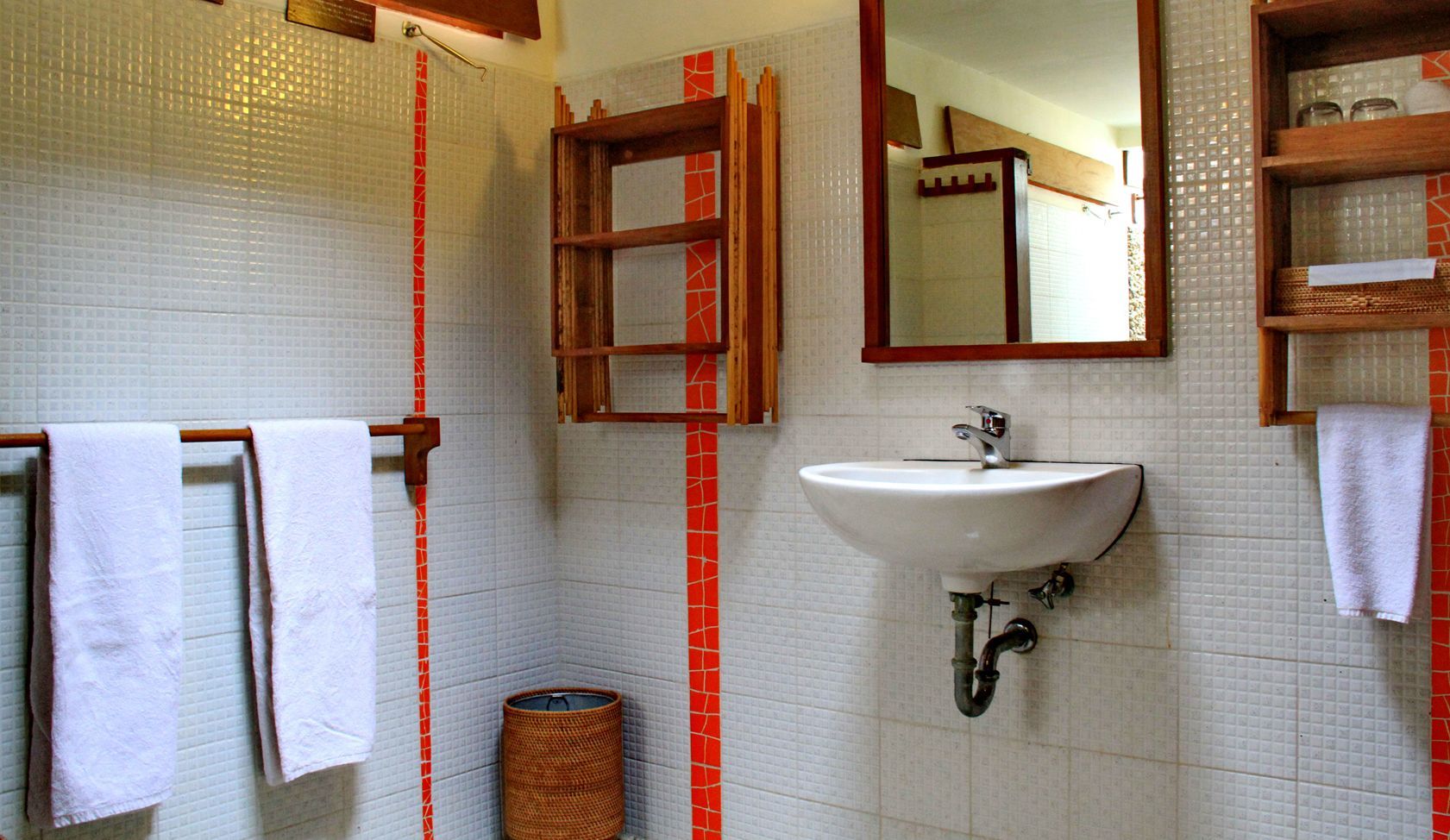 A bathroom with a sink , mirror and towels
