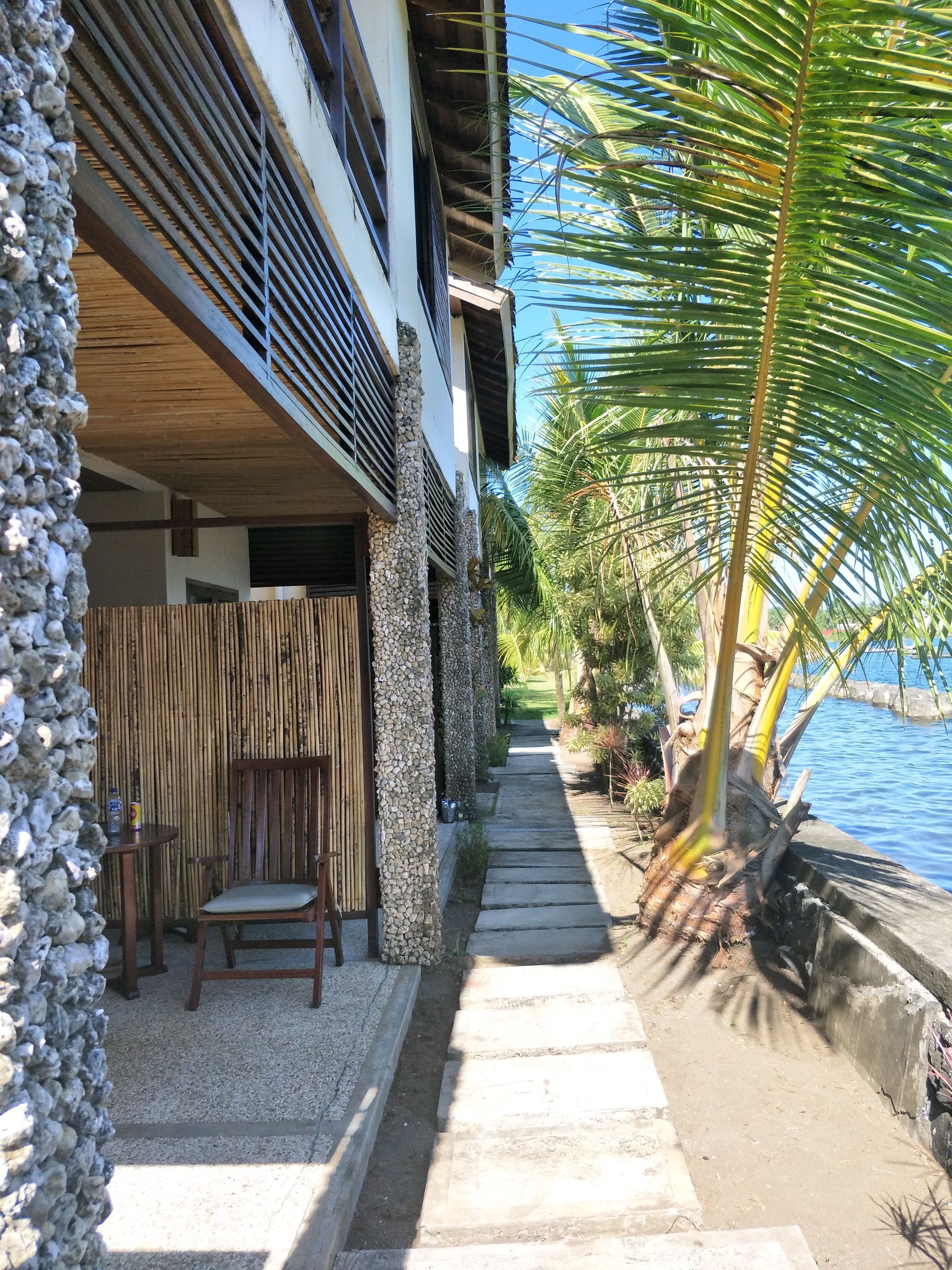 A walkway leading to a house next to a body of water.