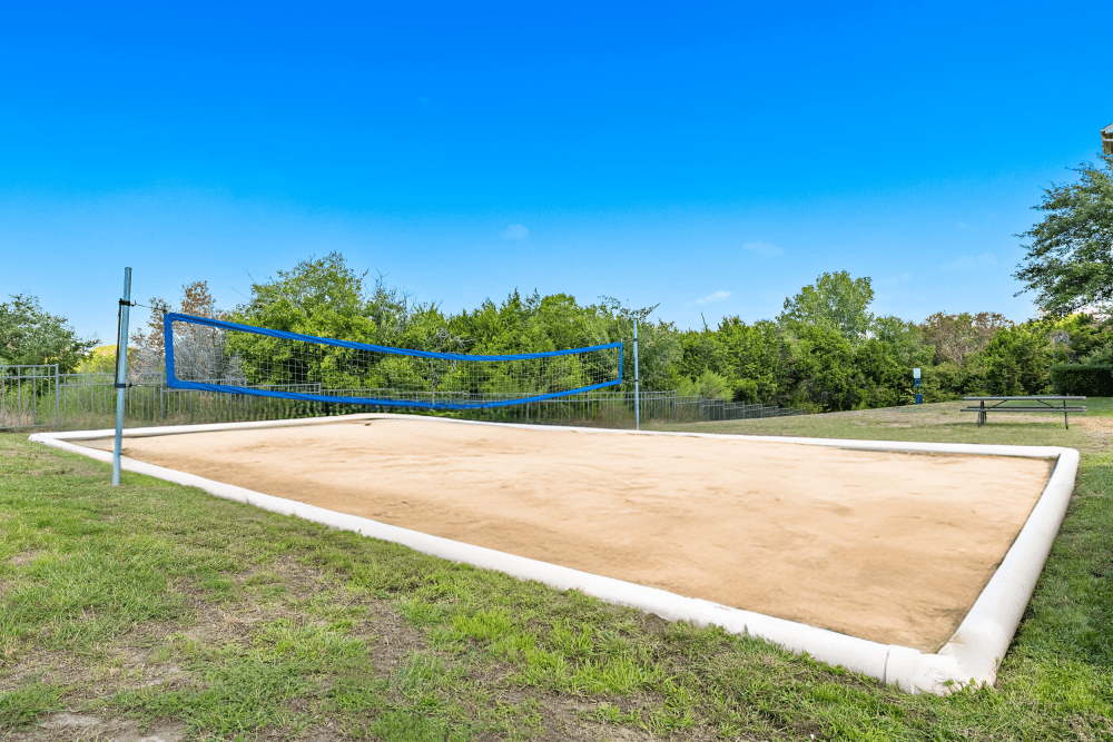 a volleyball court in a park with a blue sky in the background at Marquis at Canyon Ridge in Austin, TX.